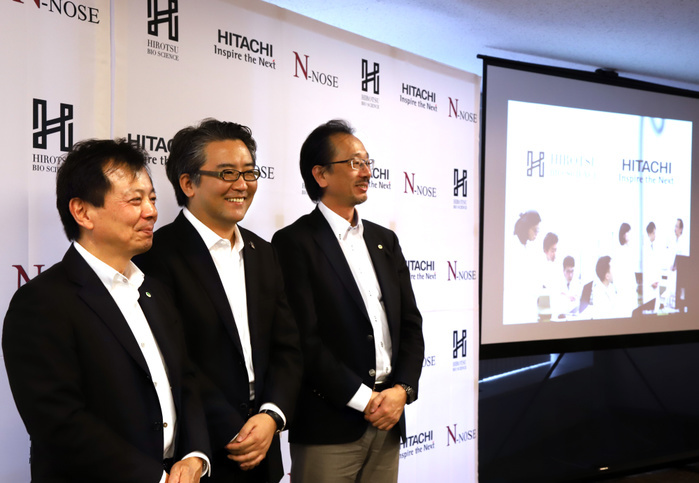Cancer Inspection by Nematodes: Development of a Device for Practical Use July 4, 2018, Tokyo, Japan   Japan s biomedical venture Hirotsu Bio Science CEO Takaaki Hirotsu  C  smiles with Hitachi s center for exploratory research general manager Shinji Yamada  L  and Hitachi s researcher Norihito Kuno  R  as they announced to develop N NOSE cancer screening system using nematodes in Tokyo on Wednesday, July 4, 2018. N NOSE  Nematodes nose  system is based on chemotaxis of nematodes. Nematodes migrate towards the urine of cancer patients while move away from healthy people s urine.      Photo by Yoshio Tsunoda AFLO  LWX  ytd 