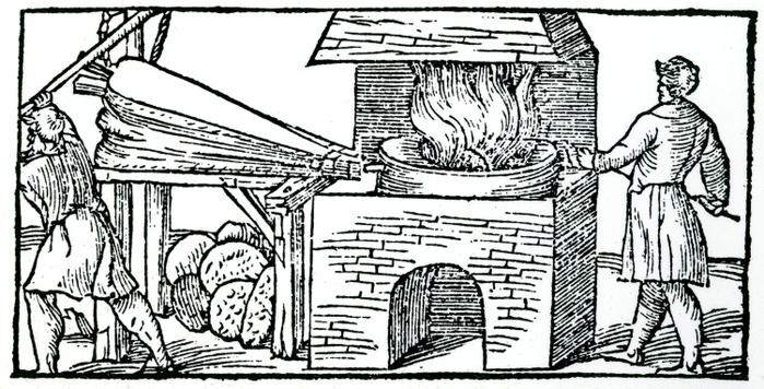 Using bellows to increase draught in furnace for refining copper. Note cupellation cakes of partially refined copper beneath the bellows. From Vannocio Biringuccio 'De la Pirotechnia', Venice 1540.