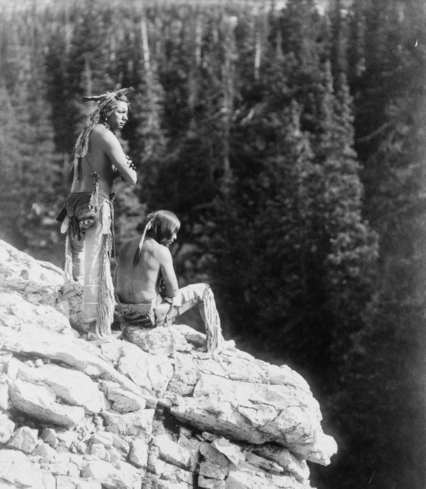 Two Native Americans looking over the edge of a cliff, c1912.  Photograph by Roland W. Reed (1864-1934).