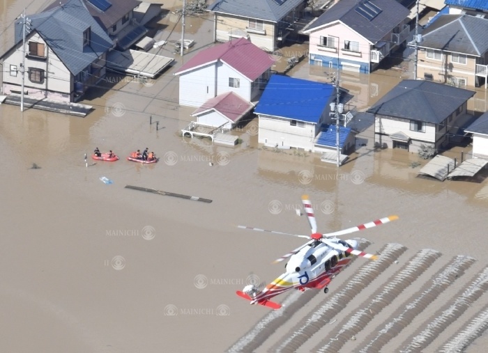 Firefighting helicopters and rubber boats rescue people in an urban area where muddy water remains from the torrential rains in western Japan Aerial view of Kurashiki, Okayama A firefighting helicopter and a rubber boat perform rescue operations in an urban area where muddy water remains, in the Mabi cho district of Kurashiki City, Okayama Prefecture, Japan, July 8, 2018, 3:49 p.m. Photo by Nobushi Kako from the headquarters helicopter.