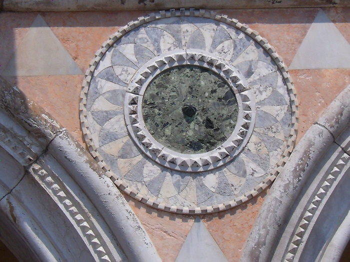 (Detail) architectural feature on the facade of the Doge's Palace in Venice, Italy. The palace was the residence of the Doge of Venice, the supreme authority of the Republic of Venice. Its two most visible façades look towards the Venetian Lagoon and St. Mark's Square, or rather the Piazzetta. The use of arcading in the lower stories produces an interesting 'gravity-defying' effect. There is also effective use of color contrasts. It replaced earlier fortified buildings of which relatively little is known. Giovanni and Bartolomeo Bon created the Porta della Carta in 1442, a monumental late-gothic gate on the Piazzetta side of the palace. The palace was badly damaged by a fire on December 20, 1577.
