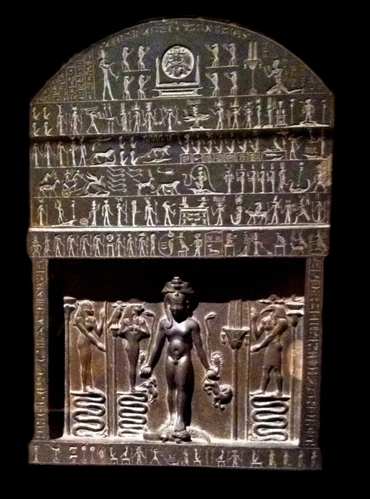 Metternich Stele, or Magical Stele 360-343 B.C. 3oth Dynasty, reign of Nectanebo II; late Dynastic period, Egyptian made from Greywacke; The top half of this stele was skilfully carved in a hard dark stone. On the part below the central figure panel, rows of hieroglyphs record thirteen magic spells to protect against poisonous bites and wounds and to cure the illnesses caused by them. In this detail of the stele