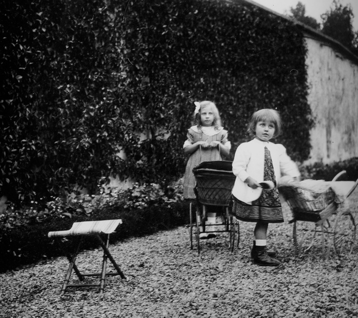 Two young French girls play in a garden. Circa 1900