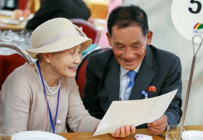 North and South Korean family members say their farewells after an inter Korean family reunion in Mt. Kumgang resort Inter Korean Family Reunion, Aug 22, 2018 : South Korean Lee Geum Seom  L, 92  and her North Korean son Ri Sang Chul  71  look at a family photo together as they bid farewell to each other at Kumgangsan hotel in Mt. Kumgang resort, North Korea in this picture taken by Joint Press Corps at Mt. Kumgang and handouted by the South Korean Ministry of Unification. Eighty nine elderly South Koreans crossed the Demilitarized Zone separating the two Koreas on August 20 to meet their North Korean relatives for the first time since they were mostly separated by the 1950 53 Korean War, during a three day inter Korean family reunion. The two Koreas have held 20 rounds of family reunions since the first ever inter Korean summit in 2000. About 57,000 South Koreans in their 70s or older are waiting to see their family members who might be living in North Korea, local media reported. Picture taken on August 22, 2018. EDITORIAL USE ONLY.  Photo by Joint Press Corps at Mt. Kumgang The South Korean Ministry of Unification Handout   NORTH KOREA 