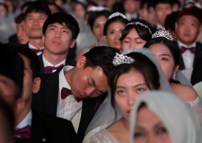 Mass wedding ceremony of the Unification Church in Gapyeong Mass wedding ceremony of the Unification Church, Aug 27, 2018 : A bride groom dozes during a mass wedding ceremony of the Unification Church at the CheongShim Peace World Center in Gapyeong, about 60 km  37 miles  northeast of Seoul, South Korea. Four thousand newlywed couples from around the world participated in the mass wedding on Monday, which was organized by Hak Ja Han Moon, wife of the late Reverend Sun Myung Moon. Rev. Moon founded the church in Seoul in 1954. The Rev. Moon, the Korean evangelist, businessman and self proclaimed messiah died of pneumonia at his religious town on September 3, 2012 at the age of 92. The church performed its first mass wedding in 1961 with 33 couples.  Photo by Lee Jae Won AFLO   SOUTH KOREA 