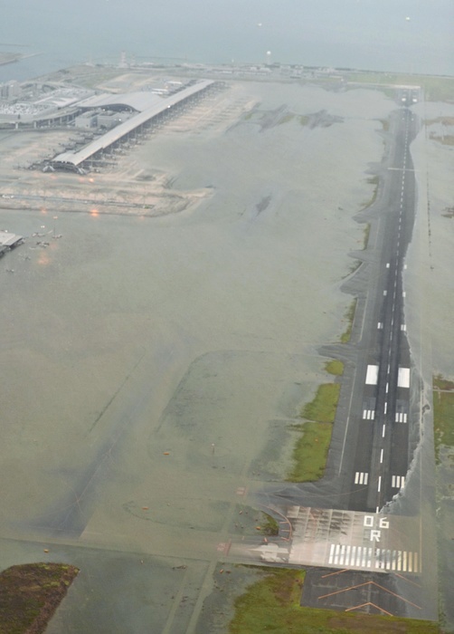Aerial view of the runway of the first phase island of Kansai Airport where sea water flowed in due to Typhoon No. 21 high tide. Typhoon No. 21 traversed Shikoku and the Kinki region from noon to evening on April 4, and passed over the Sea of Japan during the night. At Kansai International Airport, high tides caused seawater to flow in, and by 1:30 p.m. on the 4th, almost all of Runway A  3,500 meters long , one of the two runways, and the aircraft parking area were flooded. The basement of the Terminal 1 building was also flooded, causing power outages in some areas.  The runway of the first phase island of Kansai Airport flooded with seawater due to the storm surge  6:20 p.m., September 4, from the head office s helicopter . Photo taken on September 4, 2018, published in the morning edition on September 5 of the same month