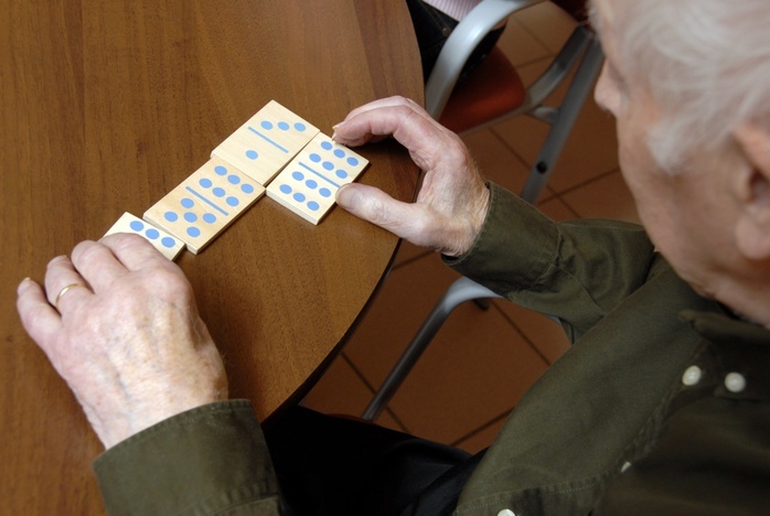 Patient with Alzheimer s disease. Elderly male Alzheimer s disease patient in a care home plays dominoes to help preserve his memory, hand mobility and dexterity. The  progression of Alzheimer s disease  dementia  can also be monitored in this way.   