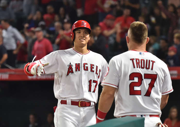 2018 MLB Ohtani No. 22 Solo Los Angeles Angels designated hitter Shohei Ohtani is greeted by teammate Mike Trout as he returns to the dugout after hitting a solo home run in the eighth inning during the Major League Baseball game against the Texas Rangers at Angel Stadium in Anaheim, California, United States, September 26, 2018.  Photo by AFLO 