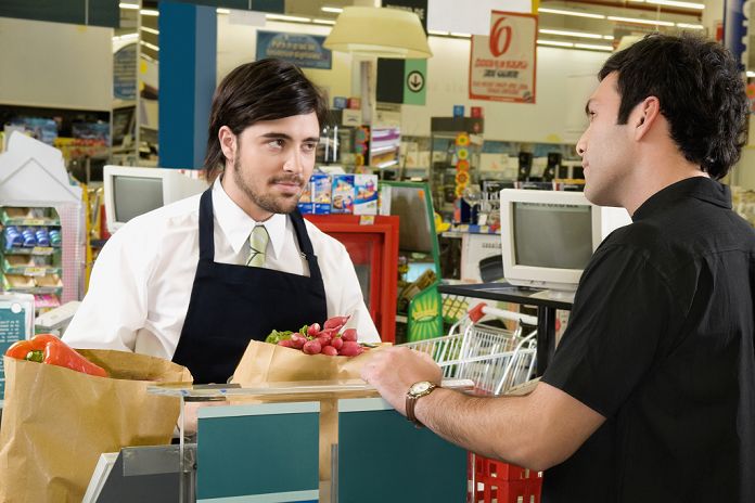 Sales clerk selling products to a costumer in a supermarket