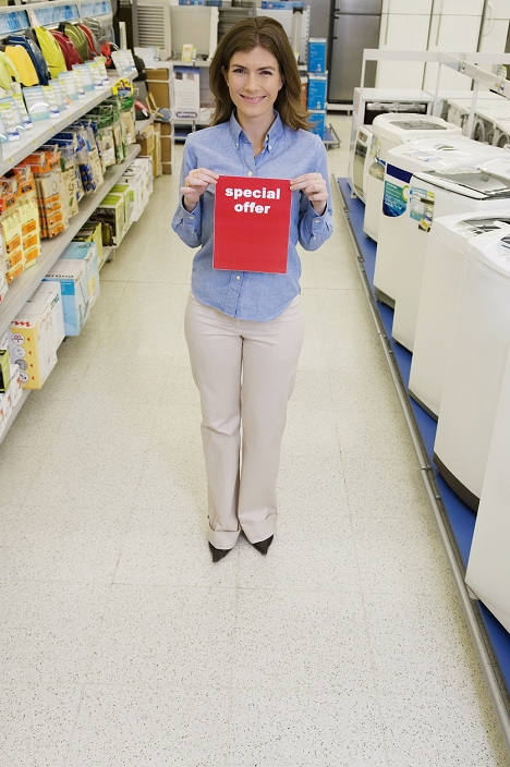 Sales clerk showing Special Offer sign in a supermarket