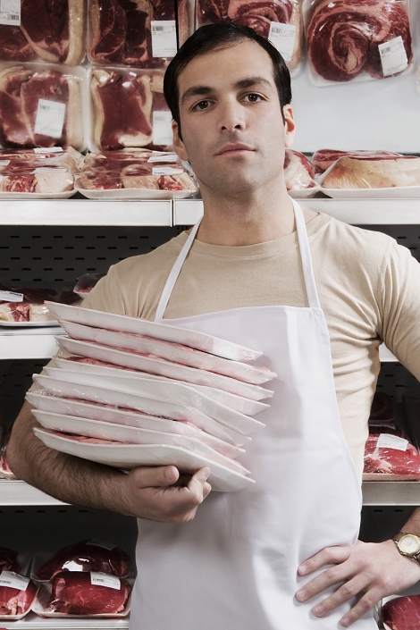 Portrait of a salesman holding meat packets