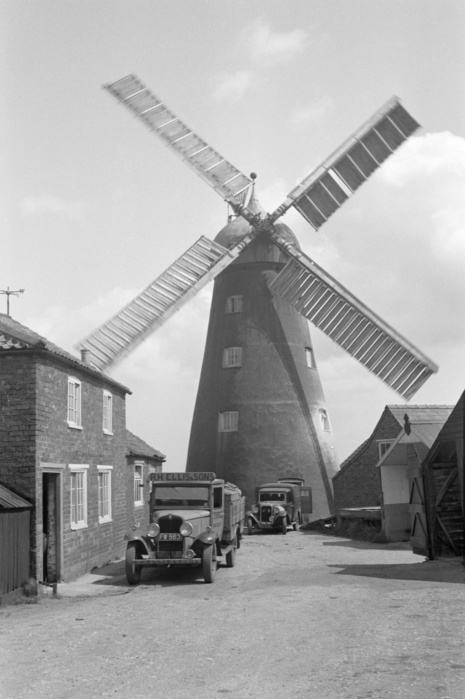 Hagg Windmill, Hagworthingham, Lincolnshire, 1935. Artist: HES Simmons. Hagg Windmill, Hagworthingham, Lincolnshire, 1935. A tower mill with an aluminium roof, built in 1810 for cereal milling. It is pictured here when it was evidently being used by RH Ellis and Sons for milling flour. The motion of the sails has caused them to appear blurred in the picture. The mill ceased working c1943.