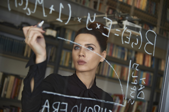 businesswoman Businesswoman writing formula on glass wall