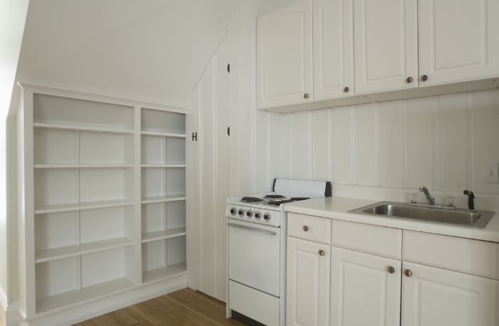 White stove and kitchen in empty apartment