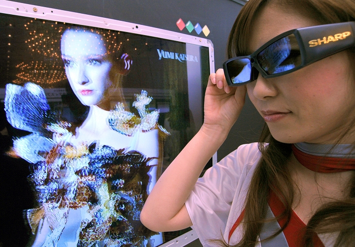 World s first 4 primary color stereoscopic LCD Sharp to launch this summer April 12, 2010, Tokyo, Japan   A model sports a pair of special 3D glasses in front of Sharp s world s first four color 3D LCD display unveiled during a news conference in Tokyo on Monday, April 12, 2010. The new four primary color technology, for the first time in the industry, adds the color yellow to the three primery color of red, green and blue. By wearing special glasses, viewers can enjoy impressive 3D images with an exceptionally realistic sense of depth, according to the manufacturer.  Photo by Natsuki Sakai AFLO   3615   mis 