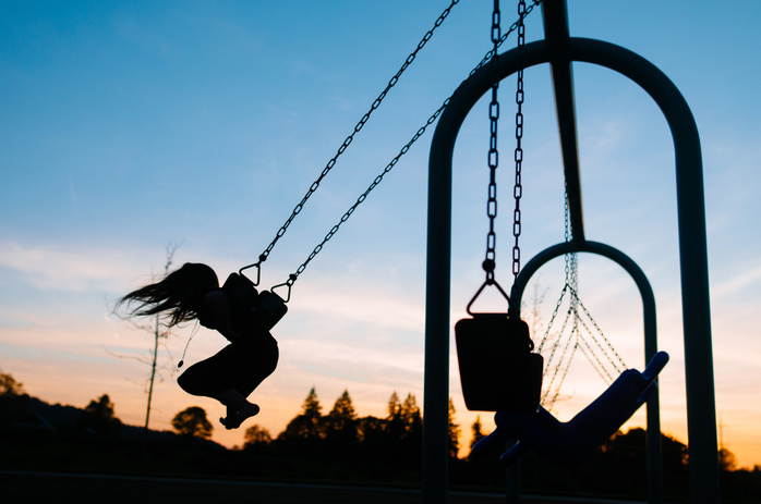 hazelachristopher.jpg Silhouette girl swinging at playground against sky during dusk