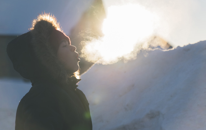 boy Side view of boy wearing fur coat while exhaling breath vapor during winter