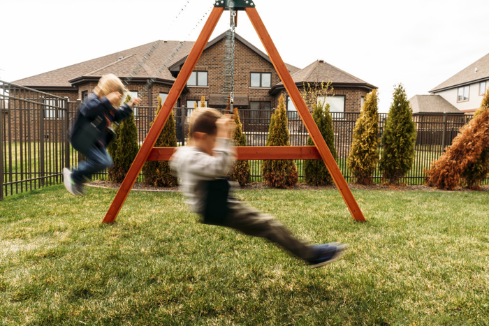 Boys playing on swings at yard