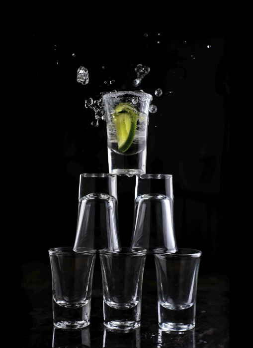 Close-up of shot glasses arranged against black background