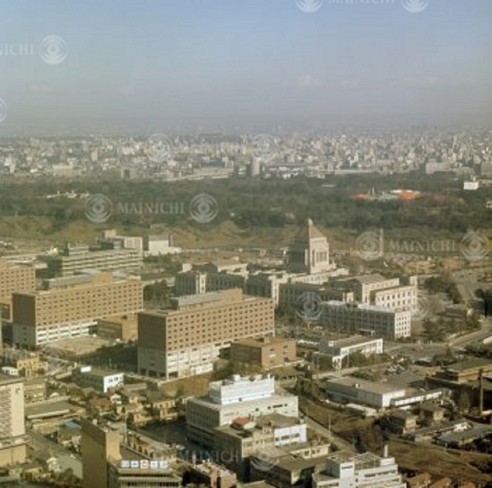 Tokyo in the 1960s Chiyoda Ward  October 1966  The Palaceside Building was completed. The Palaceside Building, seen from above  rear  and the National Diet area, was constructed in July 1964 as a new building  part of which was rented  for the Tokyo headquarters of the Mainichi Shimbun and Nippon Reader s Digest, and was completed in September 1966. Nikken Sekkei designed the building and Daelim Corporation and Takenaka Corporation jointly constructed it. The total construction cost was 10 billion yen. The building had nine stories above ground and six below, with a total area of 117,300 square meters. The building was designed with the best architectural technology of the time condensed into an innovative design that looked ahead to the 21st century. The Palaceside Building was completed. The Palace side Building  rear  and the National Diet area as seen from the sky. The new palace under construction in the Imperial Palace  right  was photographed in Tokyo s Chiyoda Ward around October 1966 by a member of the Publications Photography Department from a helicopter of the head office of the company.