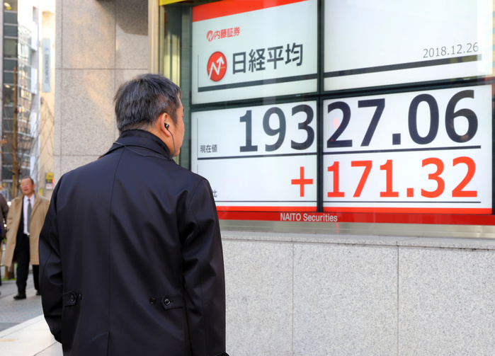 Nikkei 225 rebounds for the first time in six days, temporarily falling below 19,000 yen December 26, 2018, Tokyo, Japan   A pedestrian watches a share prices board in Tokyo on Wednesday, December 26, 2018. Japan s share prices rebounded 171.32 yen to close at 19,327.06 yen at the Tokyo Stock Exchange.    Photo by Yoshio Tsunoda AFLO  LWX  ytd 