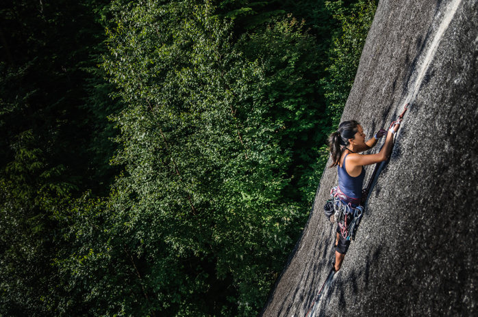 climbing Female rock climber, climbing granite rock  The Chief , elevated view, Squamish, Canada