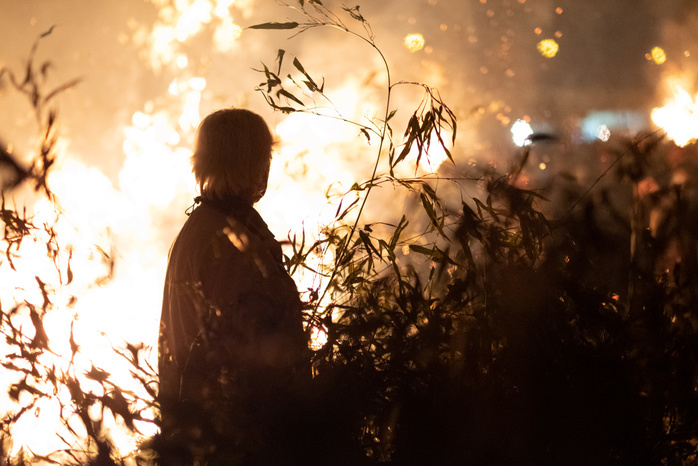 Japan, Sagicho ceremony at Oiso city A volunteer walks close to a large fire during Sagicho ceremony in Oiso on January 13, 2019. People burn old amulets and decorations for the New Year during Sagicho  also called tondo , an annual ceremony to pray for state of perfect health over the year at Sagami bay beach. January 13, 2019  Photo by Nicolas Datiche AFLO   JAPAN 