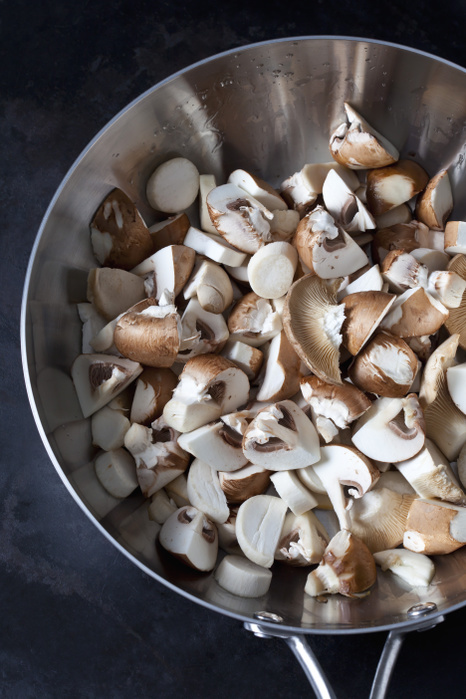 Raw champignons and king trumpet mushrooms in pan Raw champignons and king trumpet mushrooms in pan