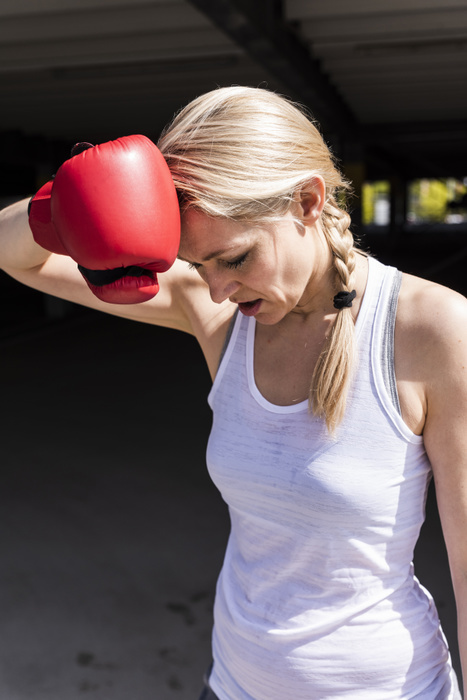 Woman with boxing gloves looking tired Woman with boxing gloves looking tired