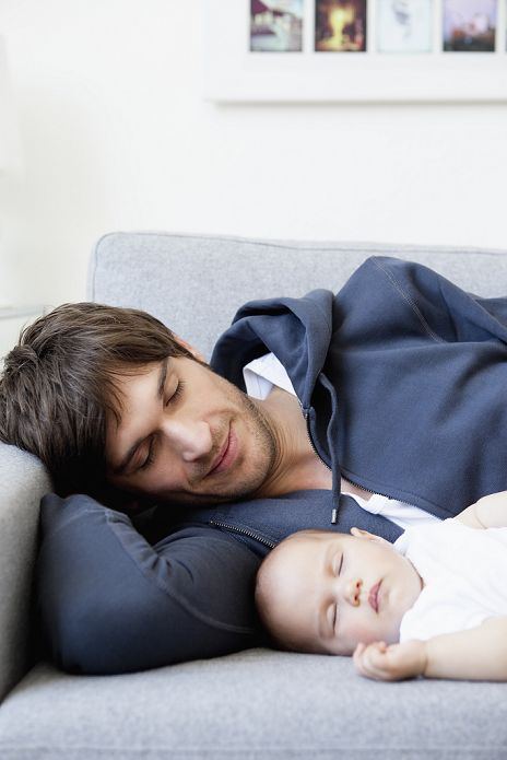Father and baby sleeping on couch