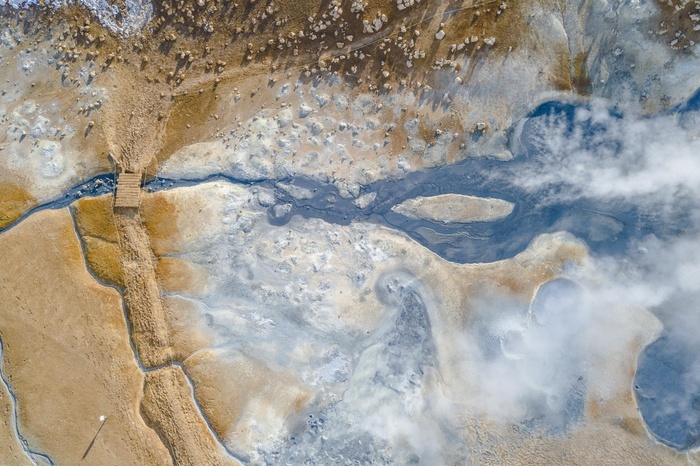 Iceland Aerial view, small bridge over steaming river and fumaroles, geothermal area Hverar nd, also Hverir or Namaskard, North Iceland, Iceland, Europe, Photo by Moritz Wolf