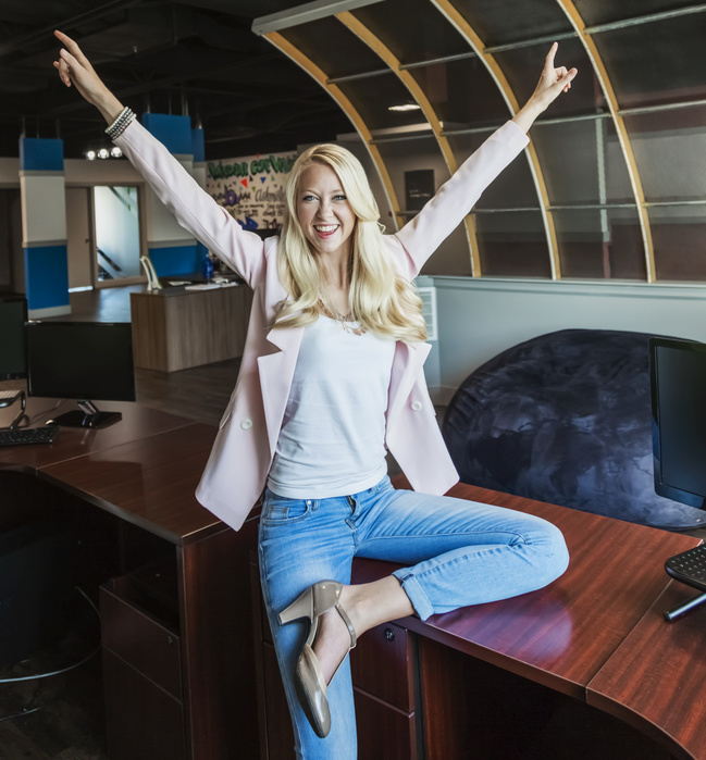 businesswoman Beautiful young millennial business woman with long blond hair celebrating success and posing for the camera in the workplace  Edmonton, Alberta, Canada