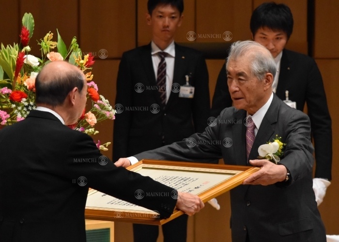 Mr. Honjo being presented with the Prefectural Special Honor Award by Governor Ishii Tasuku Honjo is presented with the Prefectural Special Honor Award by Governor Ryuichi Ishii  far left  at the Toyama International Conference Center in Otemachi, Toyama City, March 23, 2019  photo by Ikuko Aoyama.